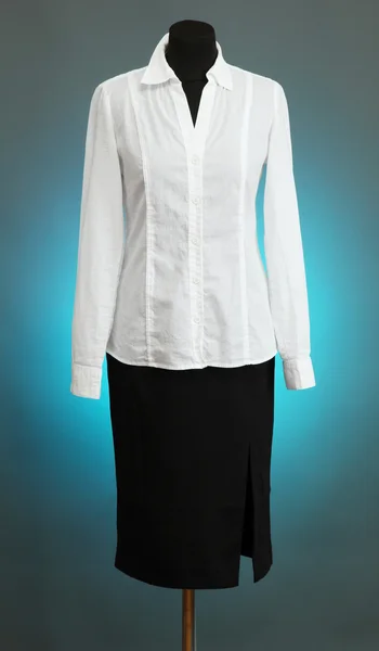 White blouse and black skirt with coat on mannequin on color background — Stock Photo, Image