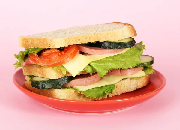 Sandwich en plato sobre fondo rosa — Foto de Stock