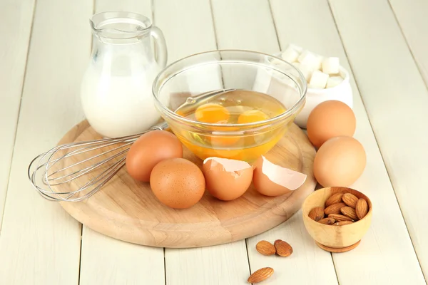 Ovo quebrado na tigela e vários ingredientes ao lado deles na mesa de madeira close-up — Fotografia de Stock