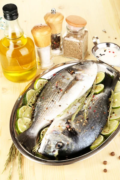 Two fish dorado with lemon on pan on wooden table close-up — Stock Photo, Image