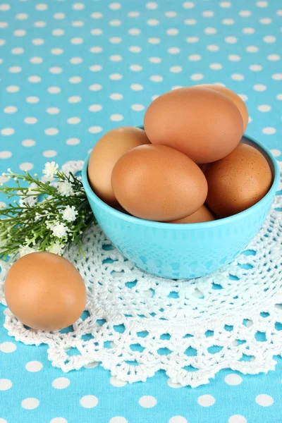 Яйца в миске на синей скатерти крупным планом — стоковое фото