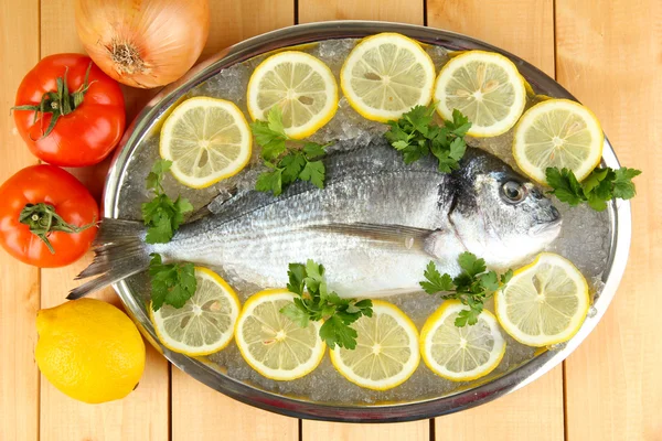 Frischer Dorado-Fisch auf Tablett mit Zitrone und Petersilie auf Holztisch — Stockfoto
