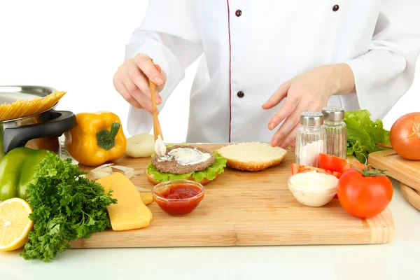 Manos femeninas preparando hamburguesa con queso, aisladas sobre blanco —  Fotos de Stock