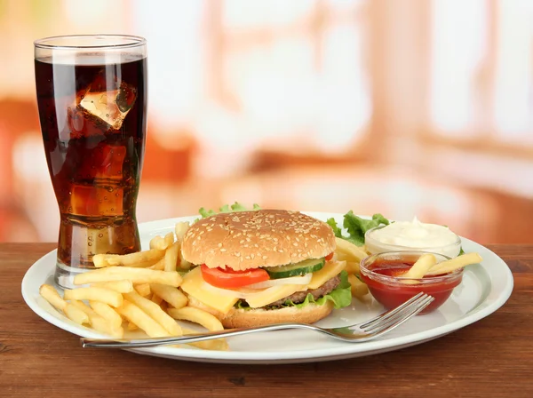 Sabrosa hamburguesa con patatas fritas y bebida fría, sobre fondo brillante —  Fotos de Stock