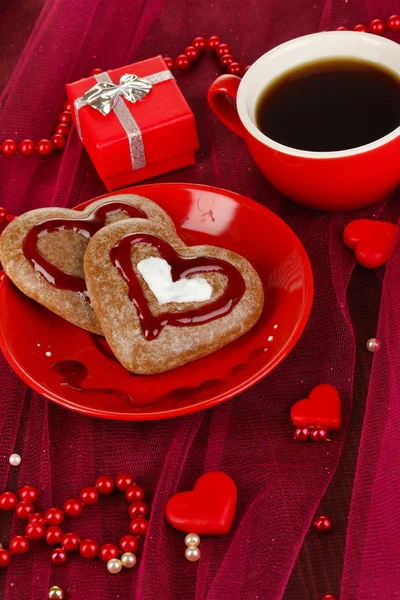 Biscuits au chocolat en forme de coeur avec tasse de café sur nappe rose close-up — Photo