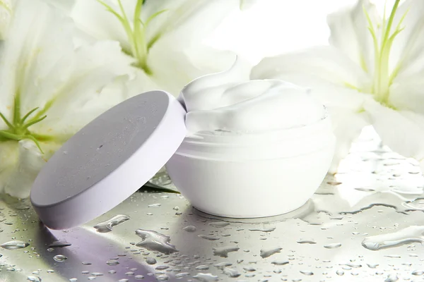 Cosmetic cream and beautiful lily, close up — Stock Photo, Image