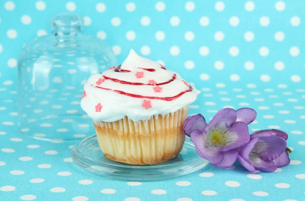 Cupcake on saucer with glass cover, on color background — Stock Photo, Image