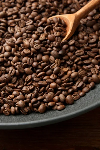 Svart wok pannan med kaffebönor på träbord, närbild — Stockfoto