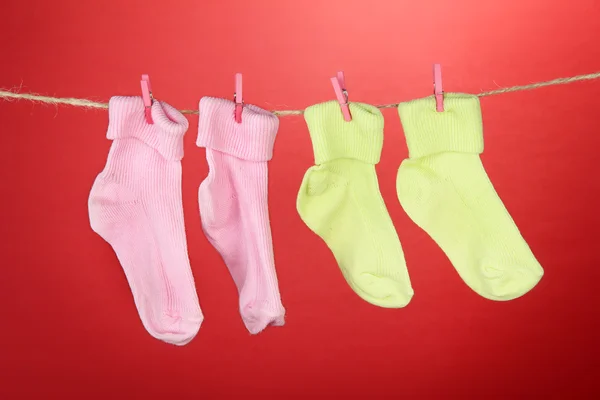 Chaussettes colorées suspendues sur corde à linge, sur fond de couleur — Photo