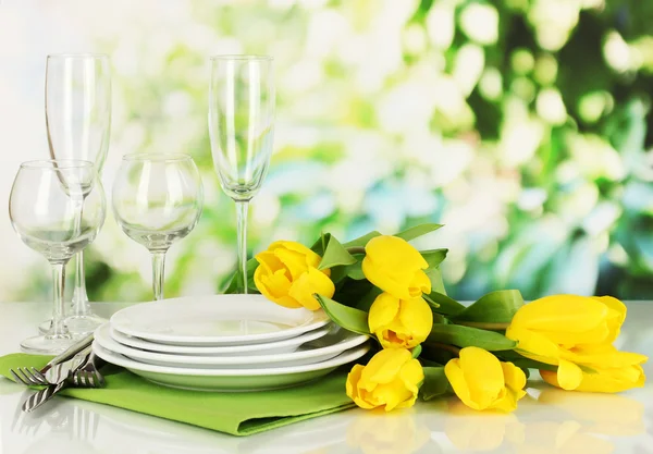 Yellow tulips and utensils for serving on natural background background — Stock Photo, Image