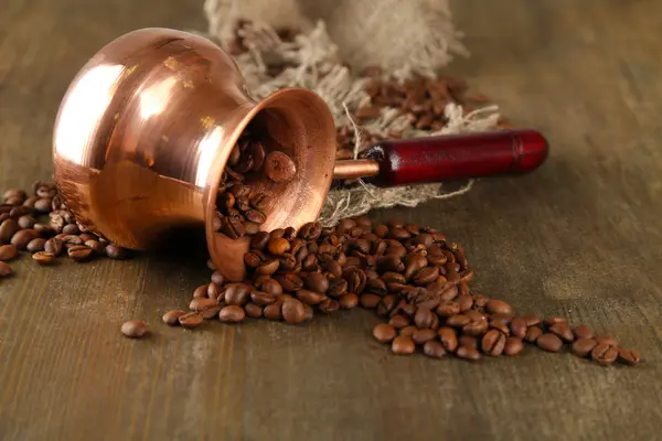 Panela de café com grãos de café no fundo de madeira — Fotografia de Stock