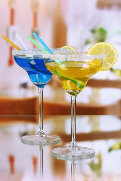 Yellow and blue cocktails in glasses on room background — Stock Photo, Image