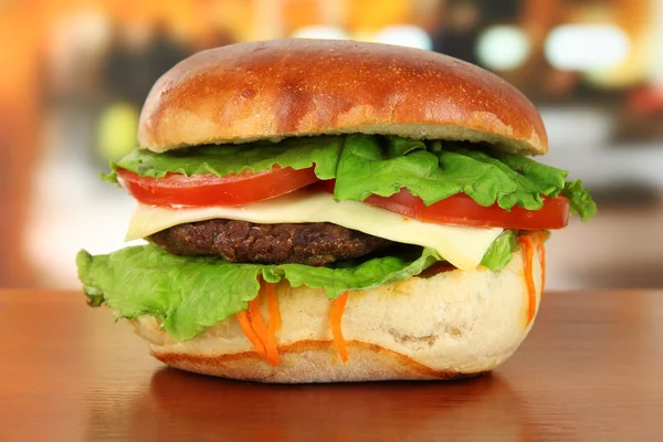 Big and tasty hamburger on table in cafe — Stock Photo, Image