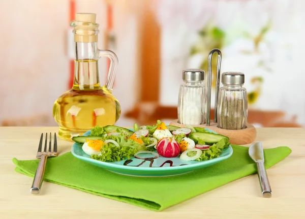 Fresh mixed salad with eggs, salad leaves and other vegetables on color plate, on bright background — Stock Photo, Image