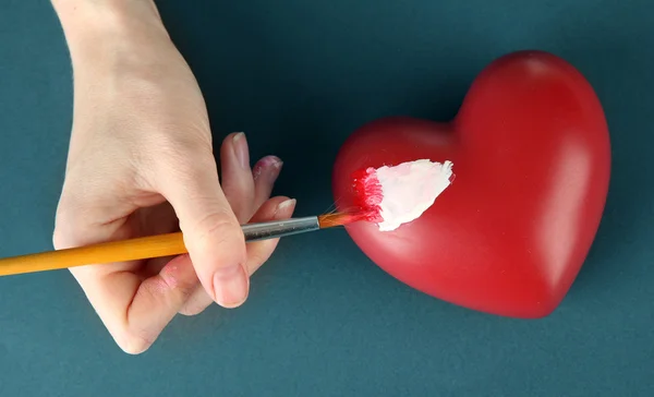 Peinture à la main tache blanche sur le cœur, sur fond de couleur. Traitement photo conceptuel des maladies cardiaques . — Photo