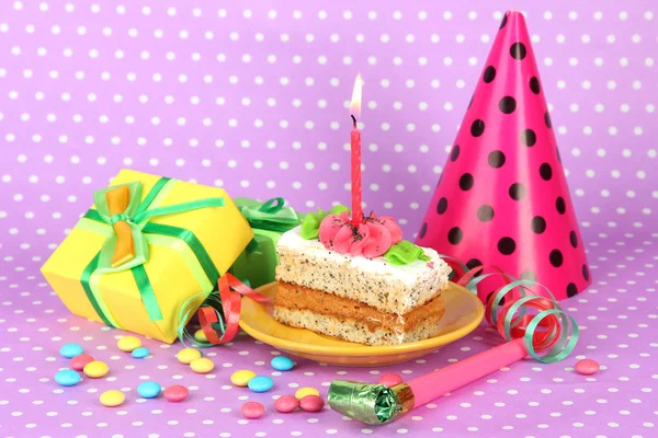 Bolo de aniversário colorido com vela e presentes no fundo rosa — Fotografia de Stock