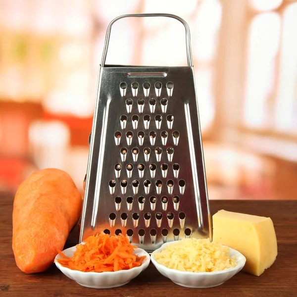 Rallador de metal y zanahoria, queso, sobre fondo brillante —  Fotos de Stock
