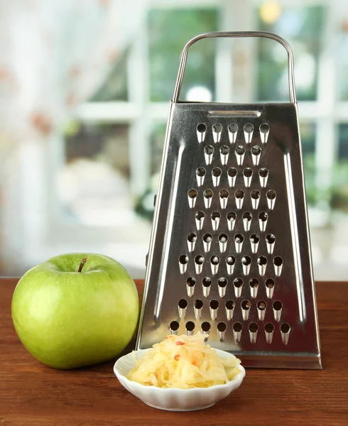 Ralador de metal e maçã, sobre fundo brilhante — Fotografia de Stock