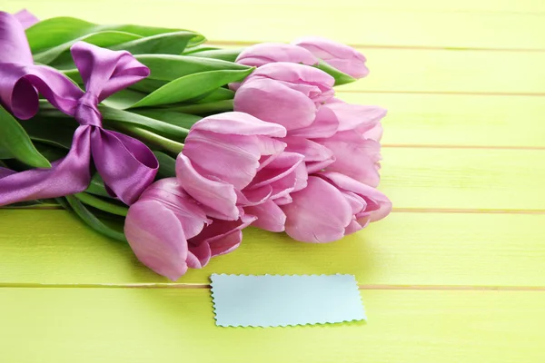 Bellissimo bouquet di tulipani viola su sfondo verde in legno — Foto Stock