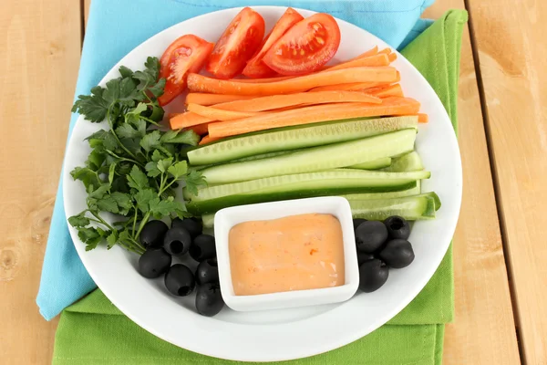 Bâtonnets de légumes crus assortis dans une assiette sur une table en bois fermer — Photo