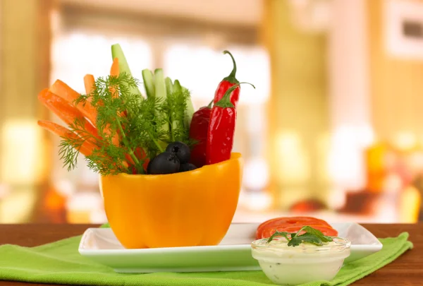 Bâtonnets de légumes crus assortis dans un bol à poivre sur une table en bois sur fond lumineux — Photo