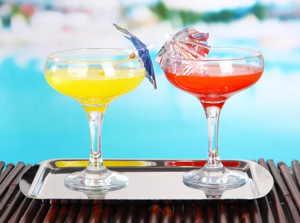 Bicchieri di cocktail sul tavolo vicino alla piscina — Foto Stock