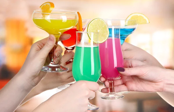 Cocktails in hands in cafe — Stock Photo, Image