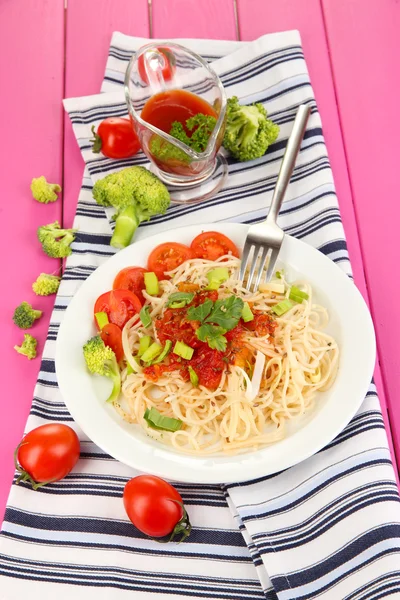 Espaguete saboroso com molho e legumes na placa na mesa de madeira close-up — Fotografia de Stock