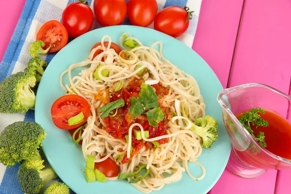 Tasty spaghetti with sauce and vegetables on plate on wooden table close-up — Stock Photo, Image