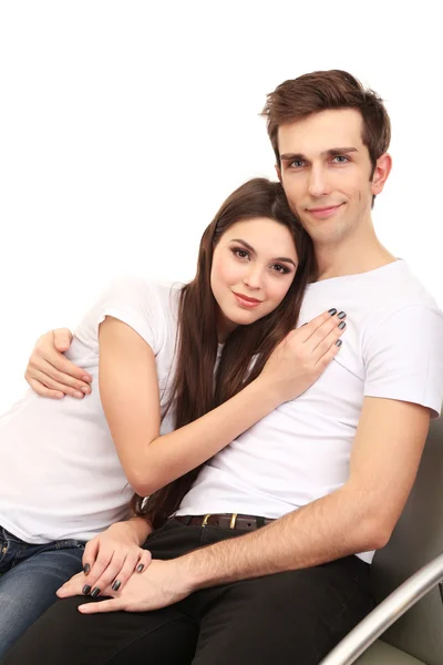 Young couple sitting together isolated on white — Stock Photo, Image