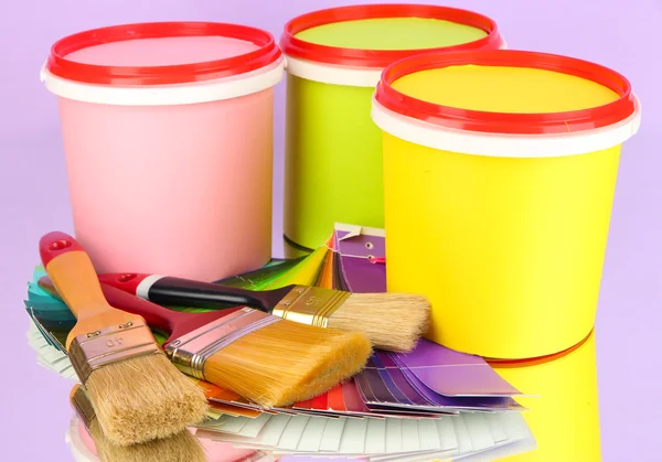 Instellen voor schilderij: schilderen potten, borstels, palet van kleuren op Lila achtergrond — Stockfoto