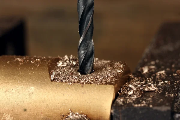 Drilling hole into metal, on wooden background — Stock Photo, Image