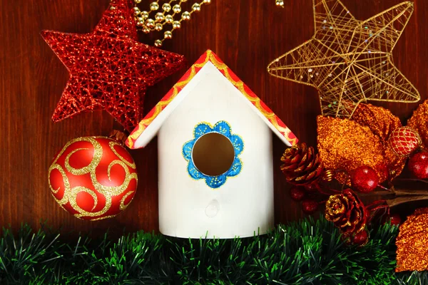 Nesting box and Christmas decorations on wooden background — Stock Photo, Image