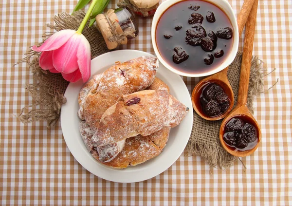 Taste croissants on plate and jam on tableclot — Stock Photo, Image