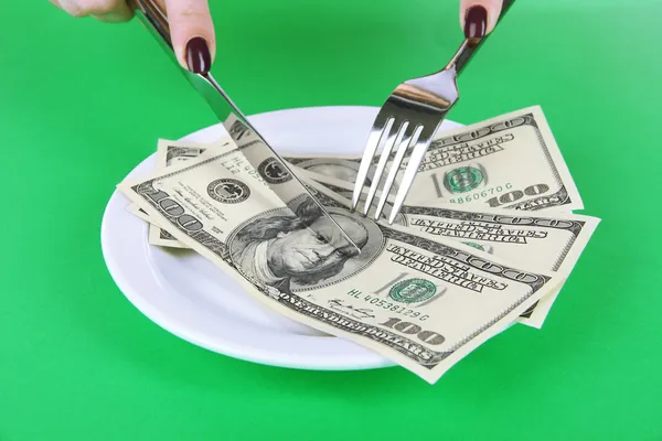 Dinero en plato sobre fondo verde —  Fotos de Stock