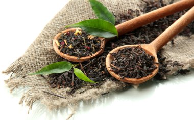 tahta kaşıklar, üzerinde beyaz izole içinde Kuru çay yeşil yaprakları
