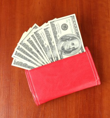 ahşap zemin üzerinde yüz dolarlık banknot ile çanta
