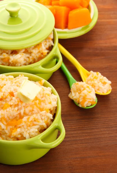 Pruebe la papilla de arroz con calabaza en cacerolas sobre fondo de madera — Foto de Stock