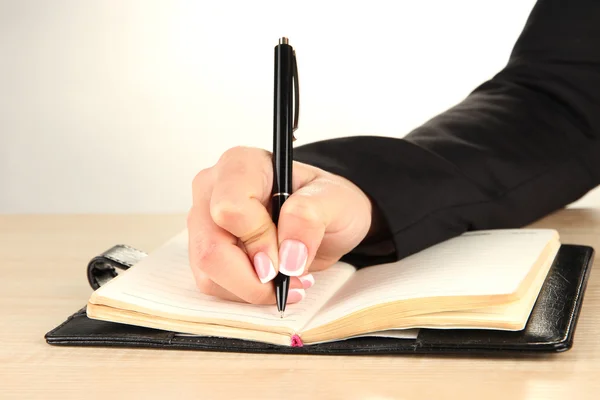 Fecho da mão de mulher de negócios, escrevendo no papel — Fotografia de Stock