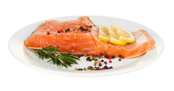 Fresh salmon fillet with herbals and lemon slices on plate, isolated on white — Stock Photo, Image