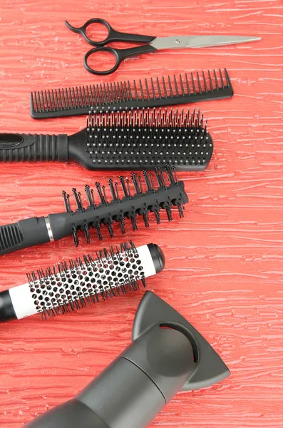 Comb brushes, hairdryer and cutting shears,on color background — Stock Photo, Image