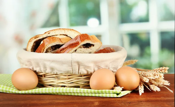 Loaf with poppy seed in wicker basket, on bright background — Stock Photo, Image