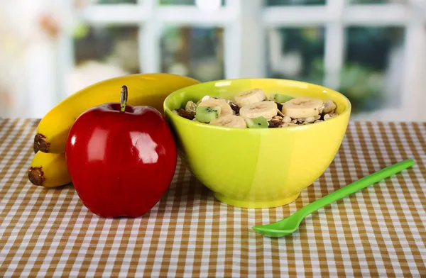 Lekker en gezond muesli in kom met fruit op tafel op kamer — Stockfoto