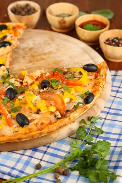 Tasty pizza with kitchen herbs on wooden table close-up — Stock Photo, Image