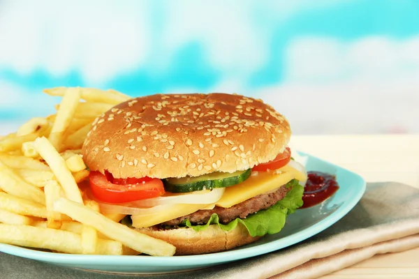 Sabrosa hamburguesa con patatas fritas, sobre fondo brillante — Foto de Stock