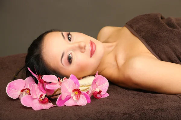 Beautiful young woman in spa salon, on dark background — Stock Photo, Image