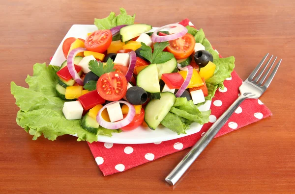 Välsmakande grekisk sallad på trä bakgrund — Stockfoto