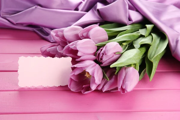 Schöner Strauß lila Tulpen auf rosa Holzgrund — Stockfoto