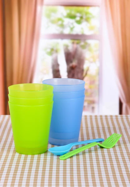 Plastikbecher, Löffel verschiedene Farben auf hellem Hintergrund — Stockfoto