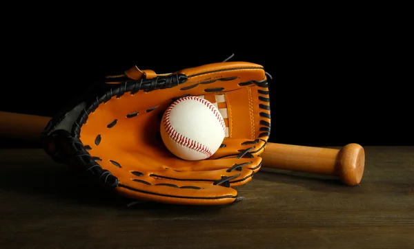 Guante de béisbol, bate y pelota sobre fondo oscuro — Foto de Stock